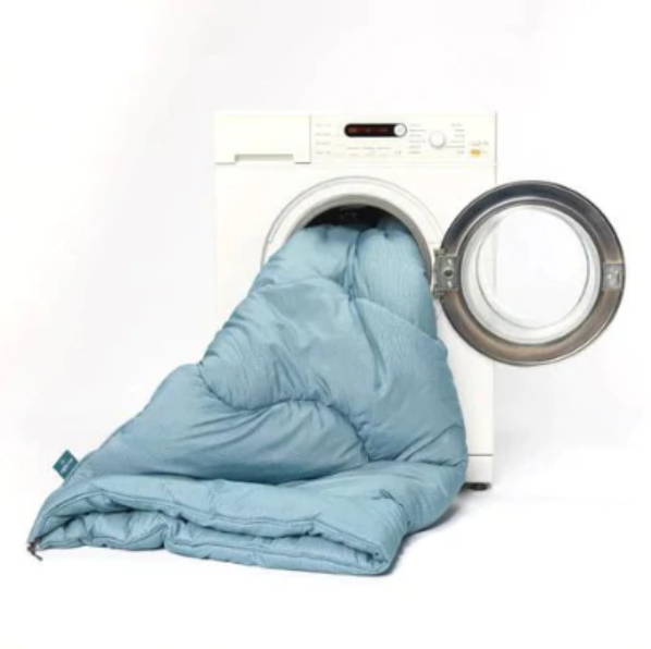 How to wash a duvet: blue duvet spilling out of washing machine